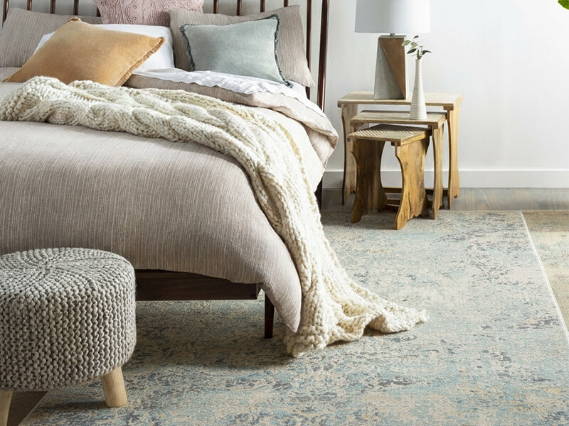 Elegantes Schlafzimmer mit einem großen handgeknüpften Wollteppich unter dem Bett